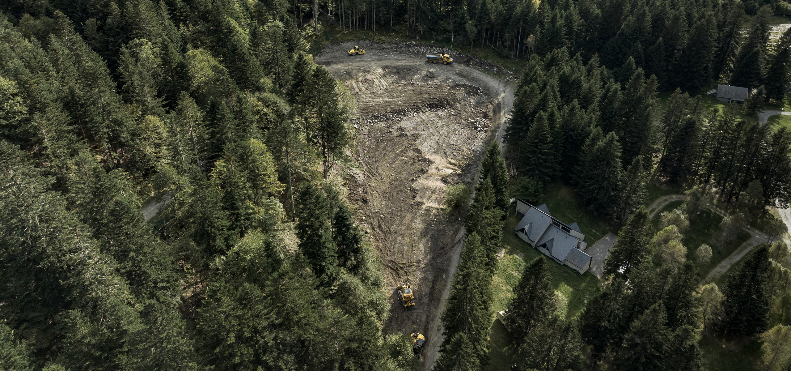 Vue aérienne drone chantier lac d'Estaing pelleteuse terrassement camion benne — photographe industriel BTP Toulouse FRAME