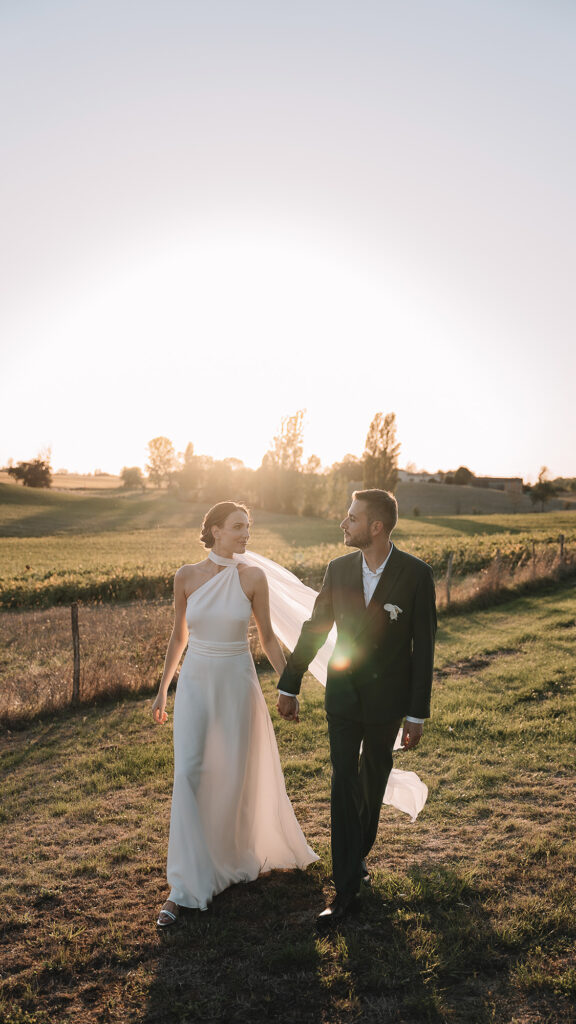 Mariés se tenant la main golden hour séance couple Villa Biloba Périgord — vidéaste mariage Toulouse FRAME
